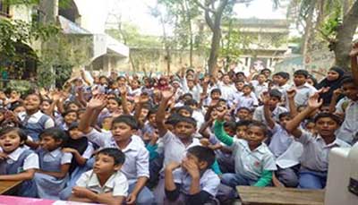 Students at Gandaria Mahila Samitee Primary School respond with hands raised